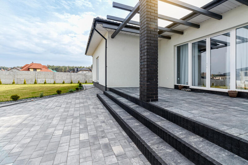 Taras z kostki betonowej w połączeniu z drewnianą pergolą
